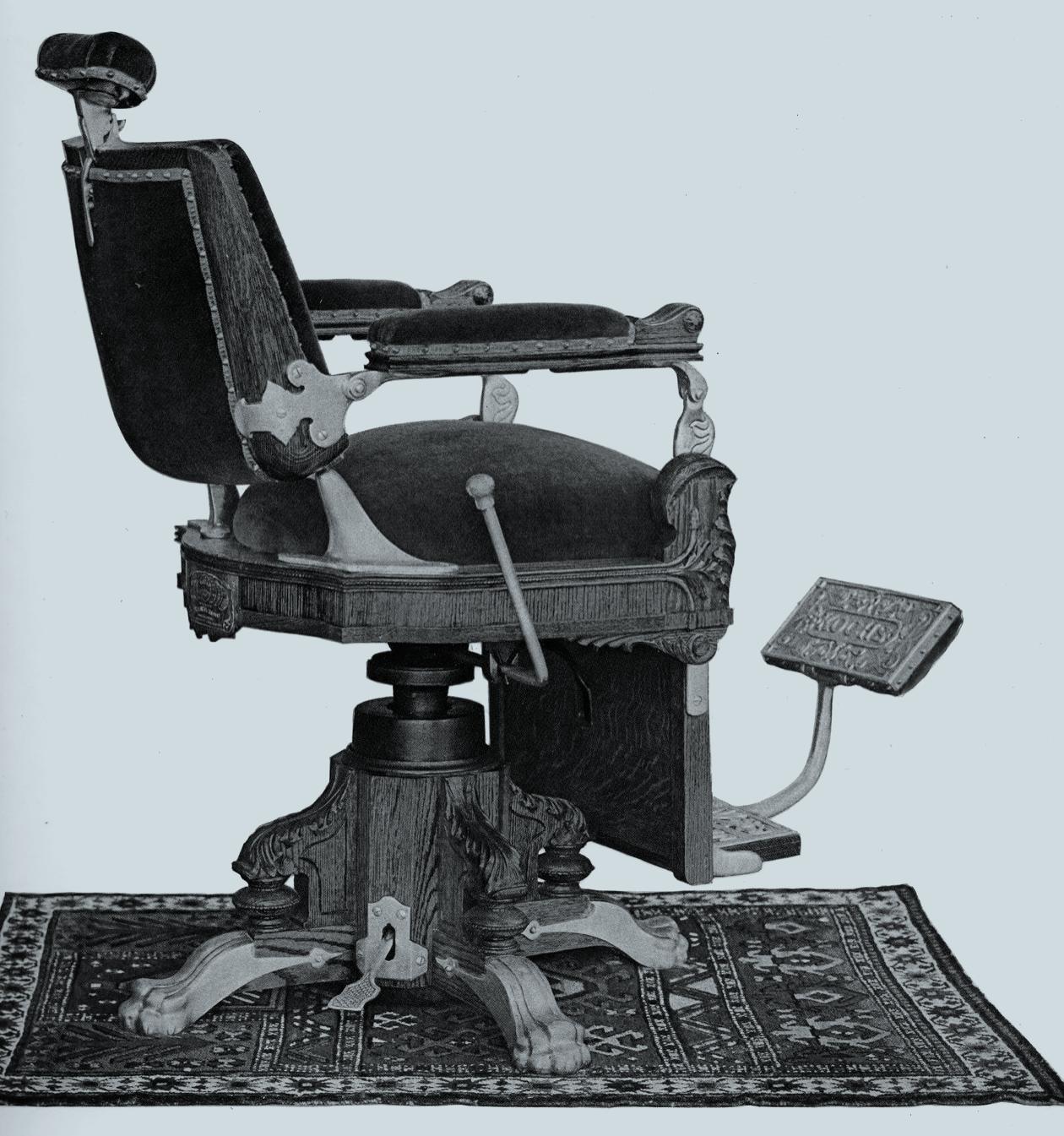 Catalogue drawing of a carved hydraulic barber chair with a padded headrest and footrest, on a patterned rug