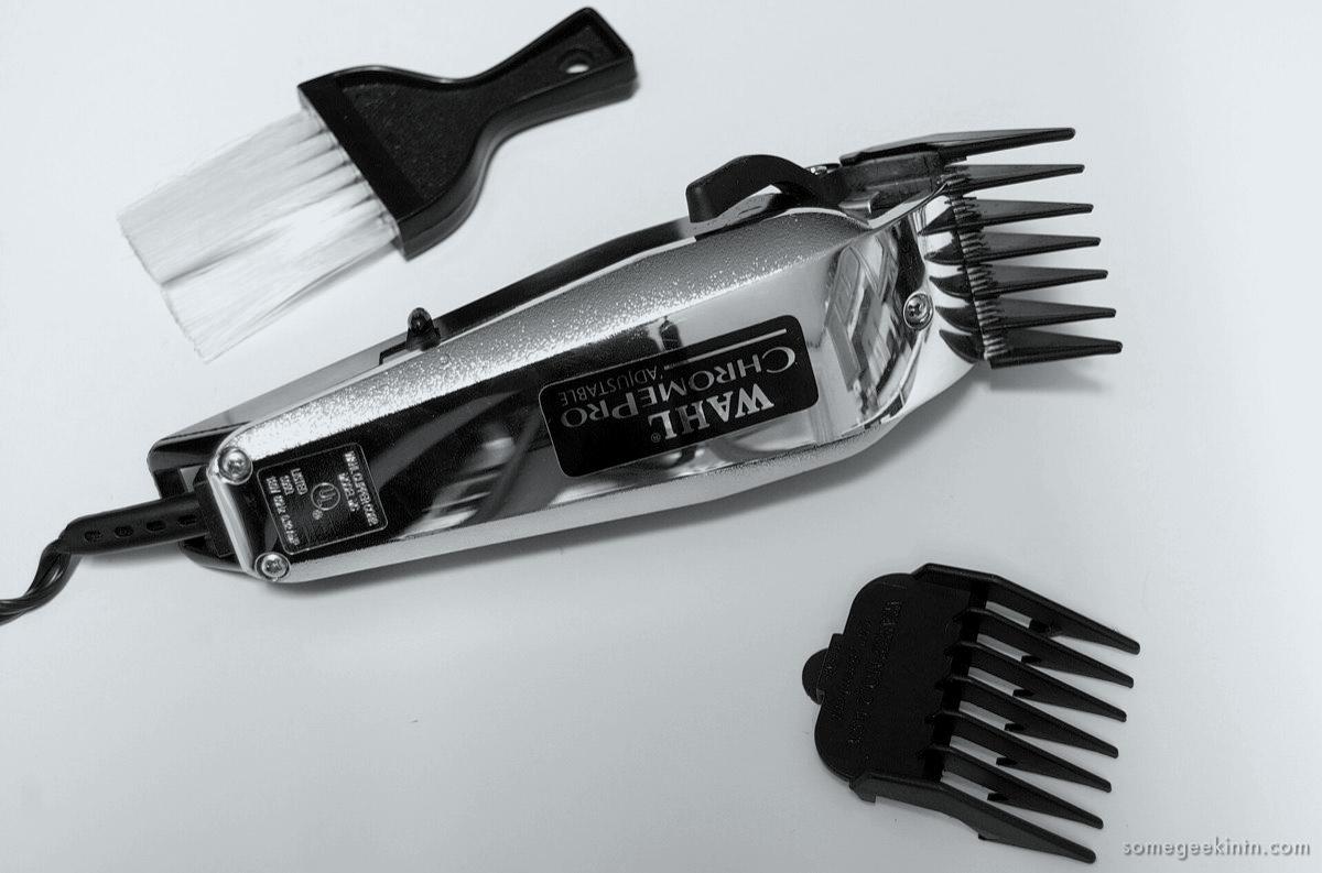 A vintage electric hair clipper with two guide combs