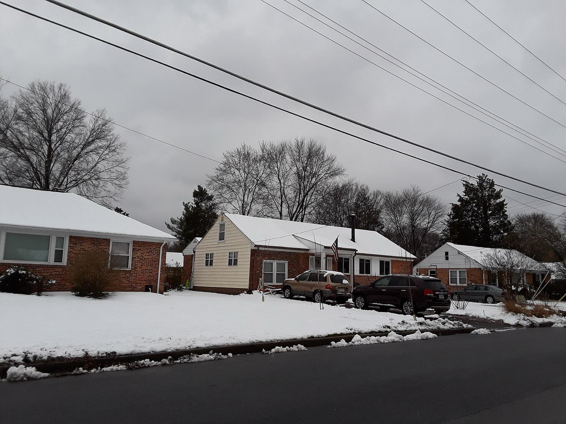A row of small houses and a snowy lawn on a grey winter evening