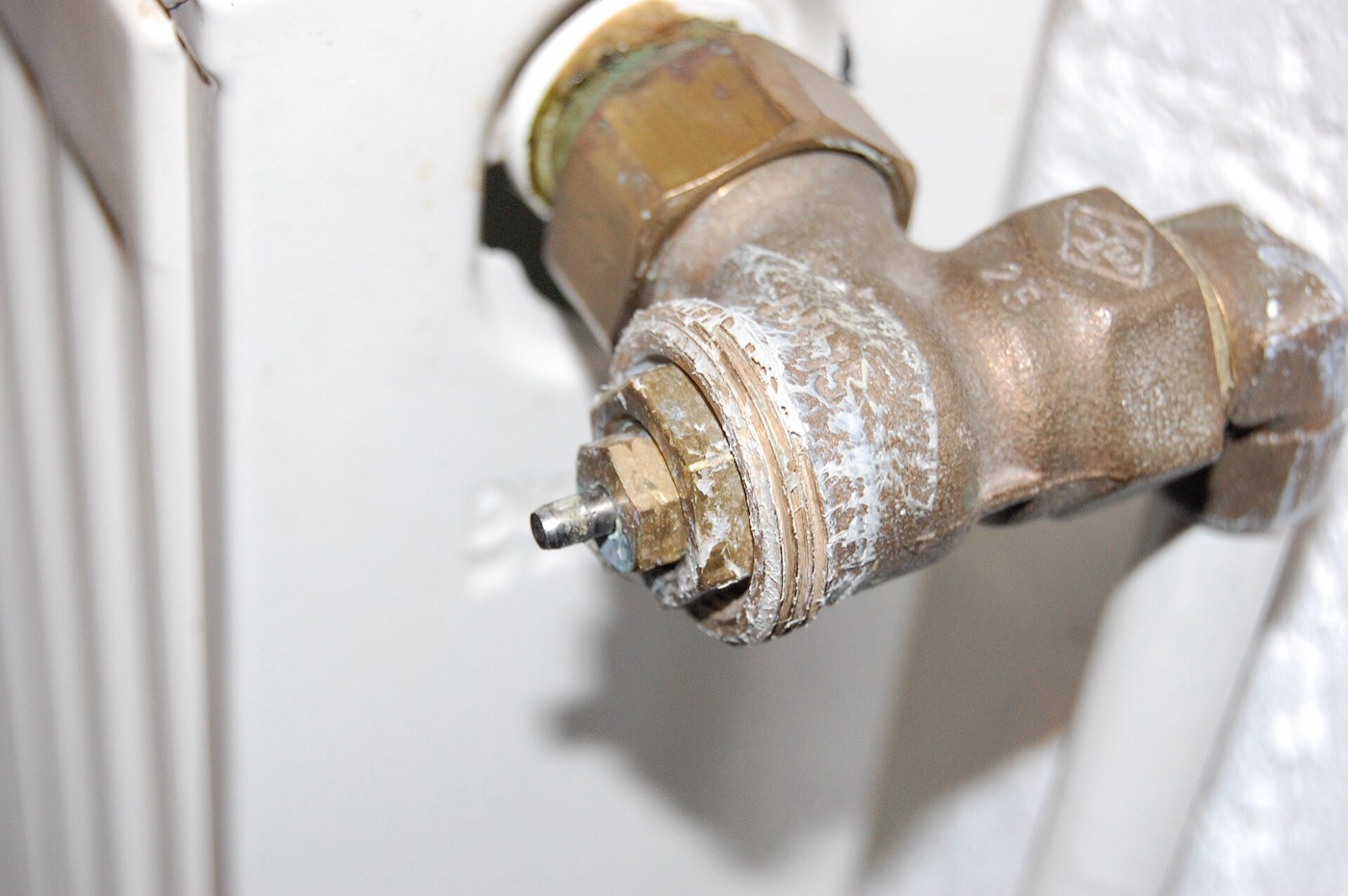 A brass valve on a white radiator