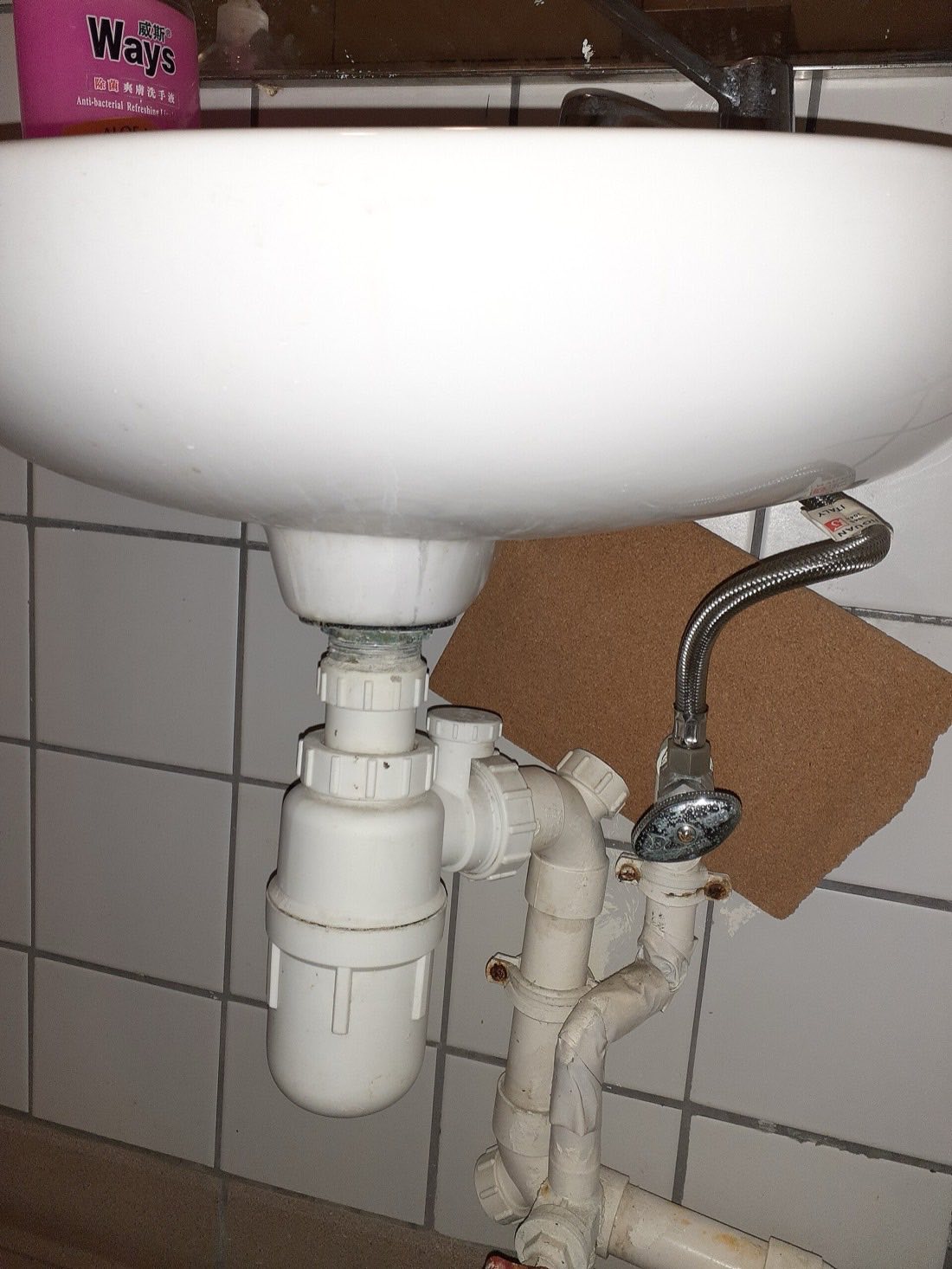 The white plastic trap and waste pipe under a wash basin